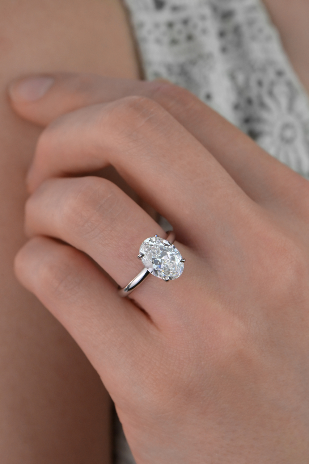 A 3ct natual oval diamond solitaire engagement ring on a finger