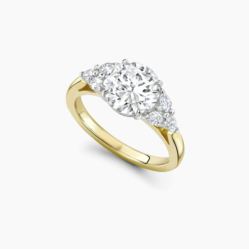 Unique 1 5ct round brilliant with pear shaped cluster side stone ring in yellow gold Through finger Perspective