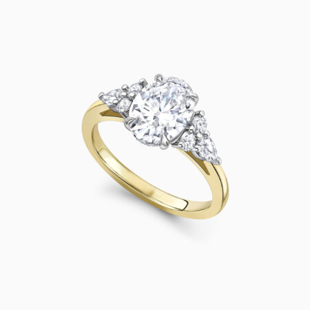 Oval cut diamond engagement ring with a cluster of intricate diamonds set either side in a unique formation created in yellow gold Falmouth Perspective